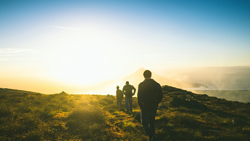 odgers berndtson - hikers walking across grassy mountain terrain