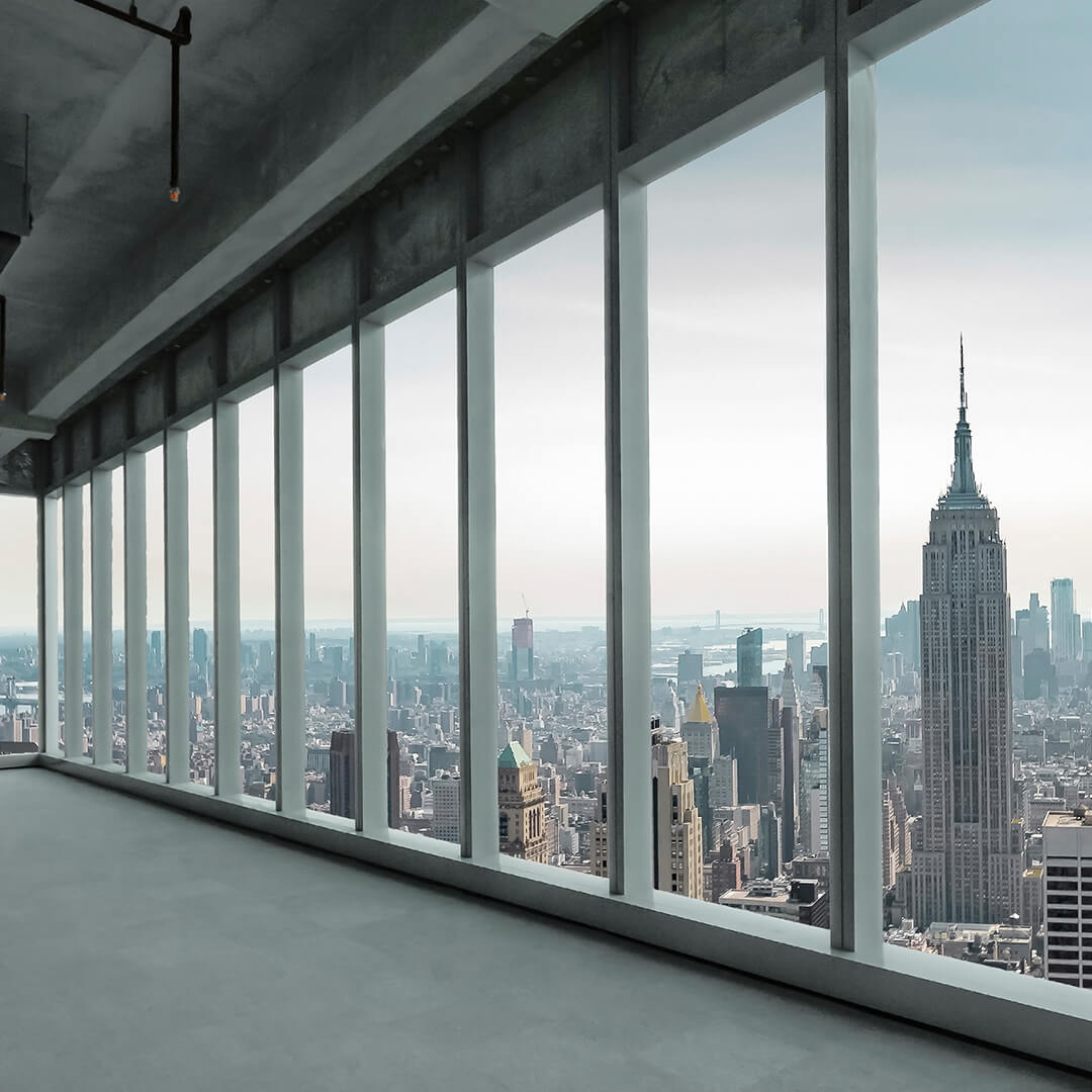 View from inside new office building looking out glass window over the city - Odgers Executive Search Board Headhunters