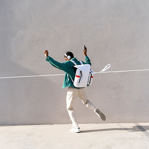 odgers berndtson - man with headphones dancing next to a wall